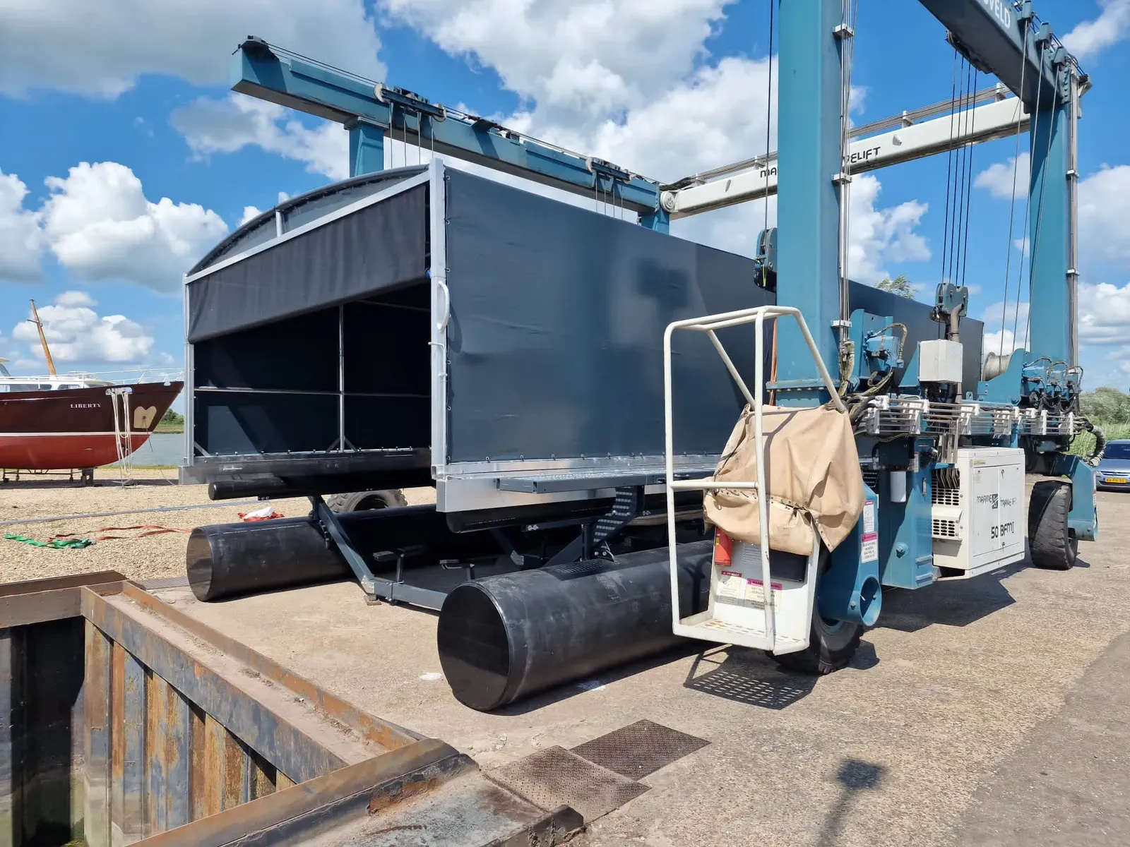 Boothuis met bootlift hangend in een portaalkraan