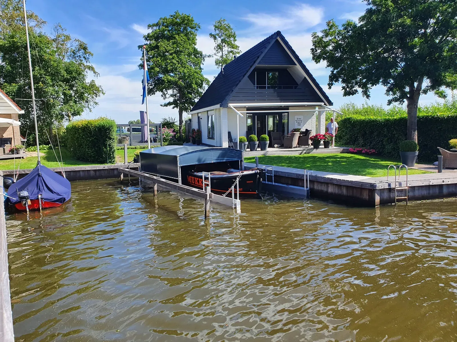 Bootoverkapping aan de kade bij een woning aan het water