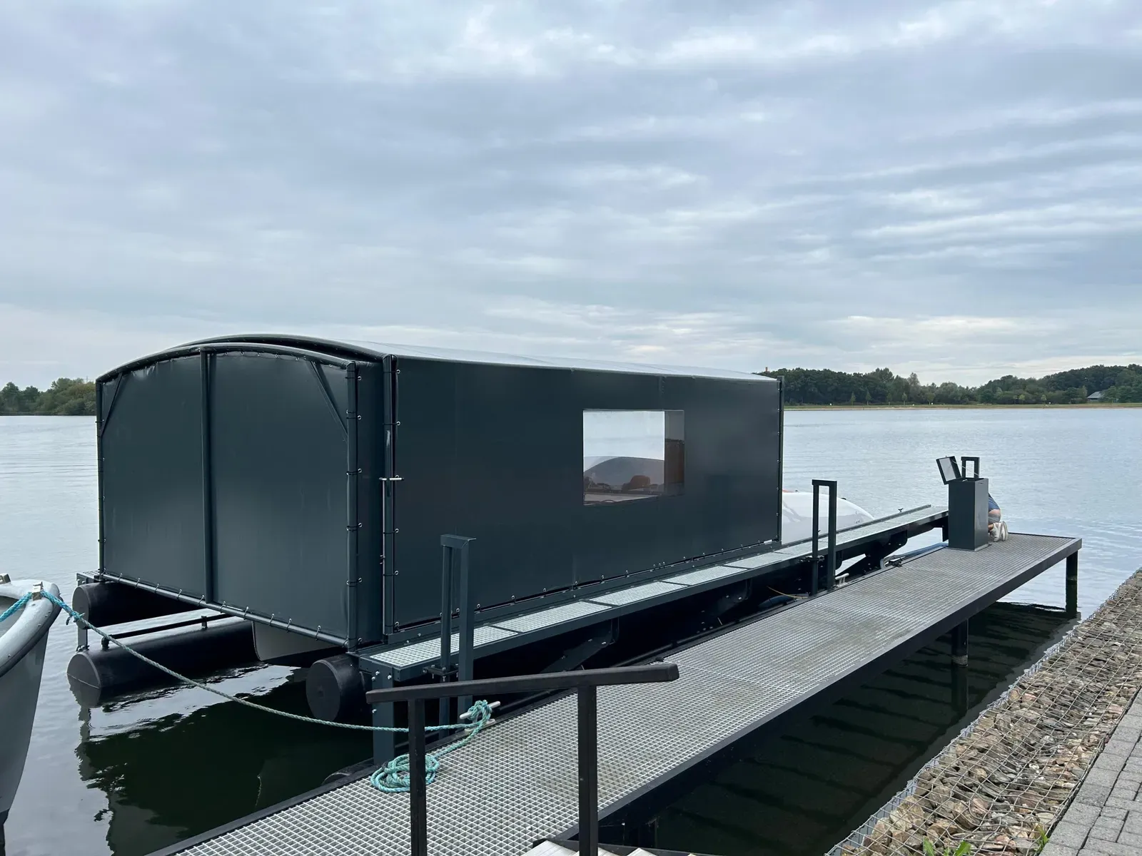 Bootoverkapping met bootlift aan een loopsteiger op een meer